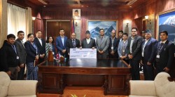 प्रधानमन्त्रीलाई चेक हस्तान्तरण गर्दै राष्ट्रिय बाणिज्य बैङ्कका कर्मचारी